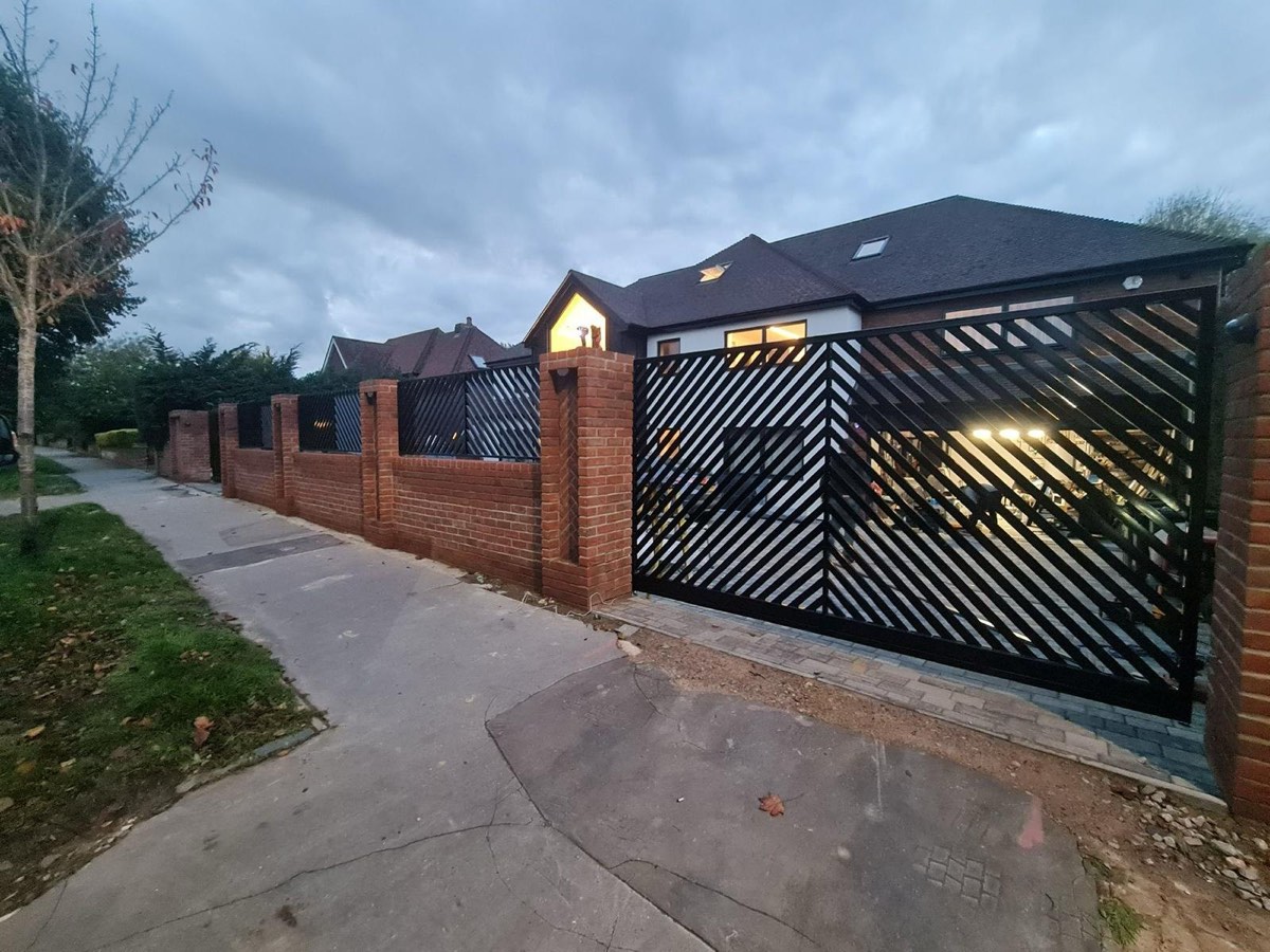 Modern bespoke steel driveway gate installed at a residential entrance